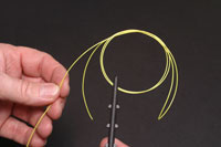 Pass the loop through the eye and tie an overhand knot at the top end of the loop