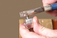 Grip head of sprue with pliers. Turn weight.